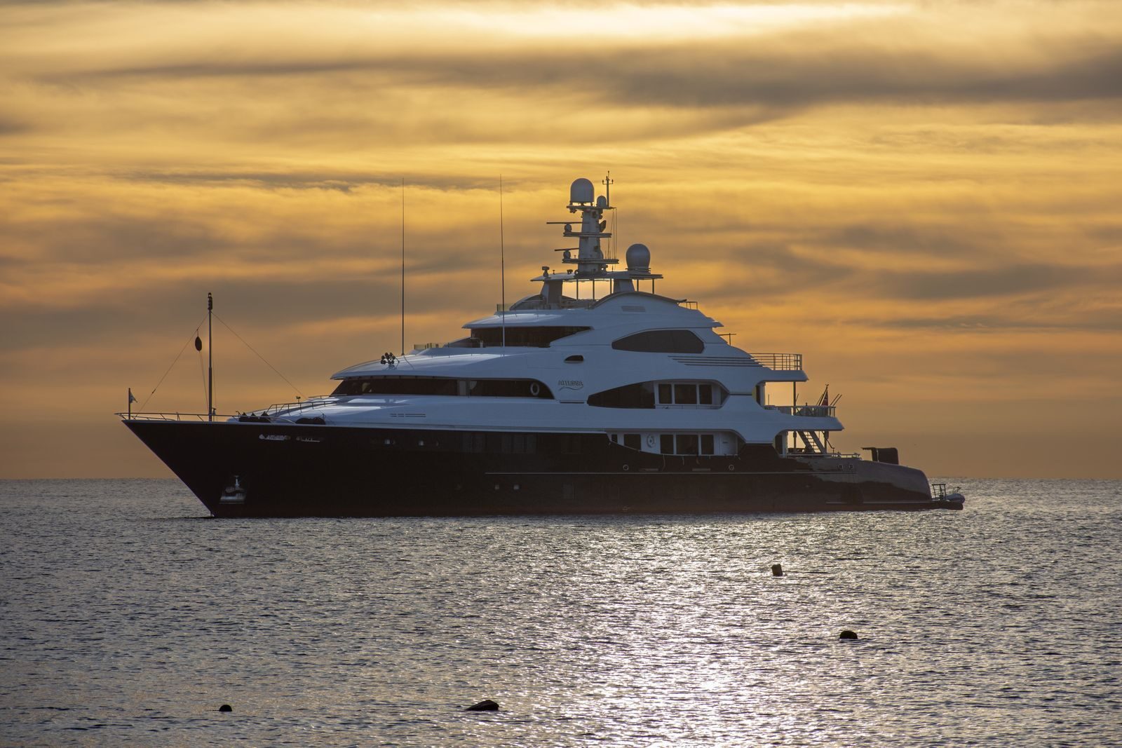 Stunning view of a luxury yacht sailing at sunset in Cabo San Lucas, Mexico's tranquil waters.