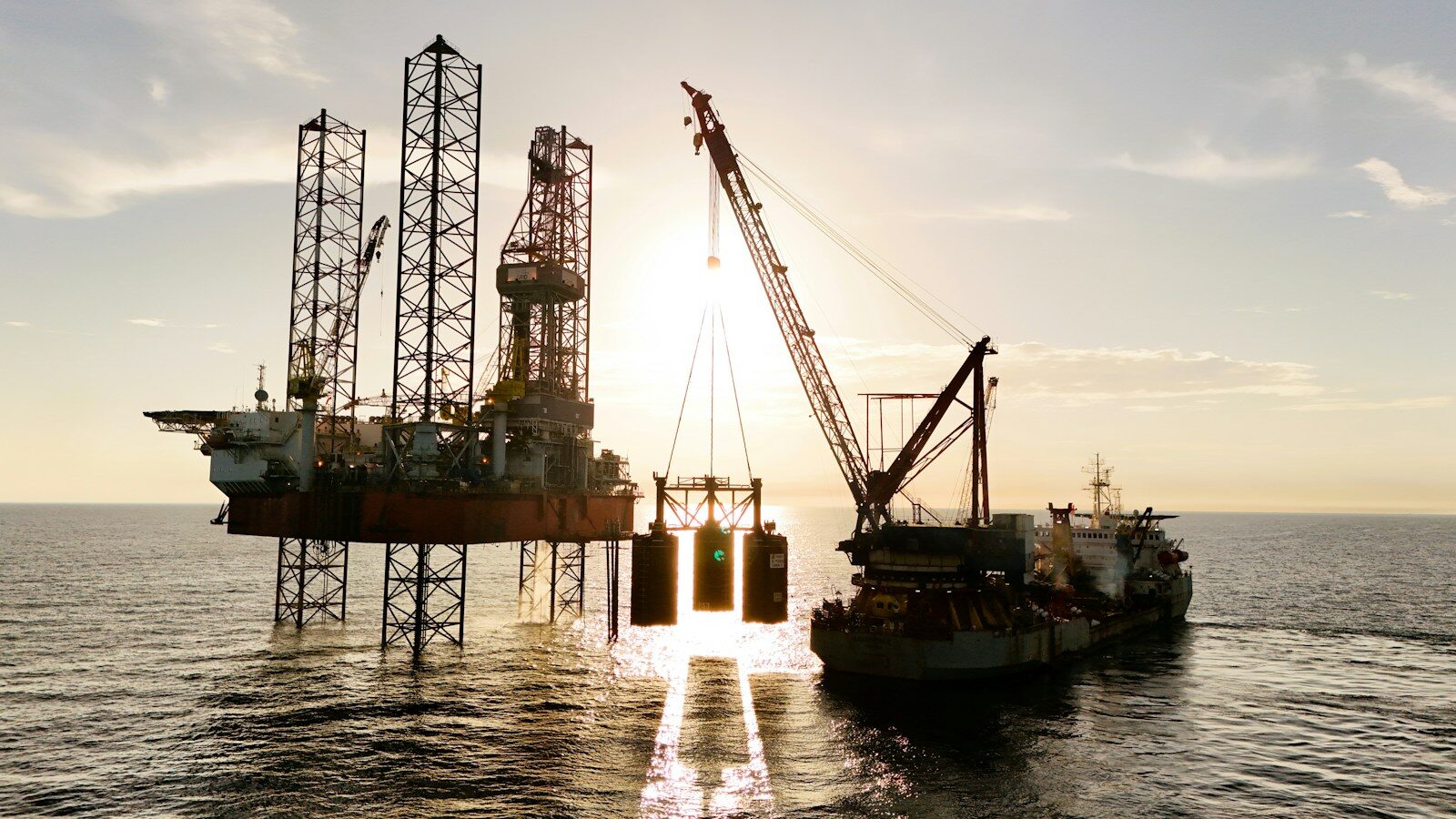 An oil rig being serviced by a supply ship