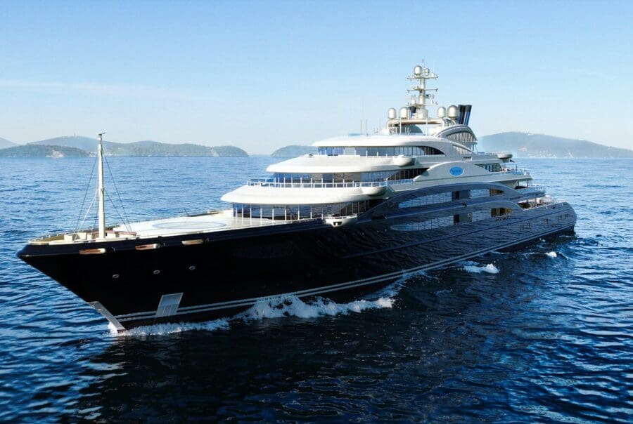 A large luxury yacht sails on blue ocean water